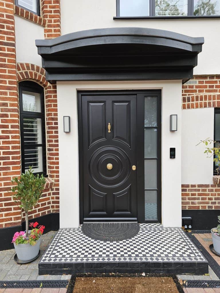 Black security door with circular design and woodpecker knocker